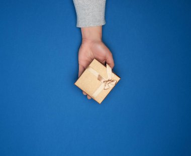 Gri kazaklı bir kadın eli kapalı bir karton giyi tutuyor.