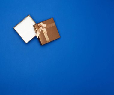 Açık kahverengi karton kutu boş, öge mavi sınıfta yatıyor