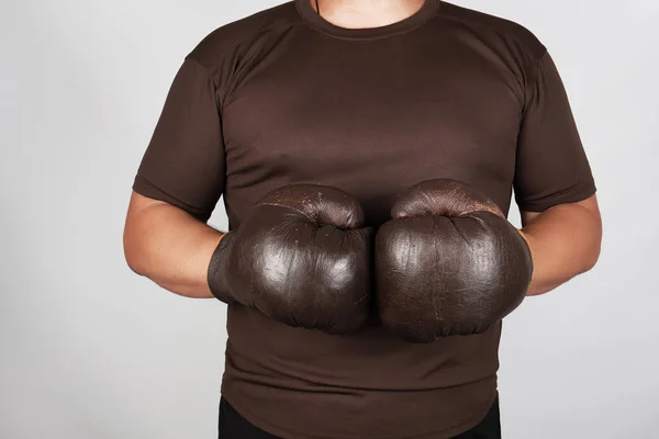 Mann steht mit sehr alten, braunen Boxhandschuhen auf dem Kopf — Stockfoto