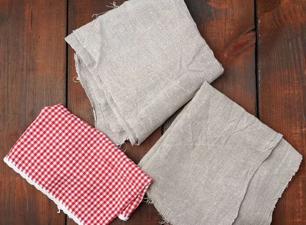 Toalla de cocina a cuadros rojo blanco y servilletas de lino gris en un br —  Fotos de Stock