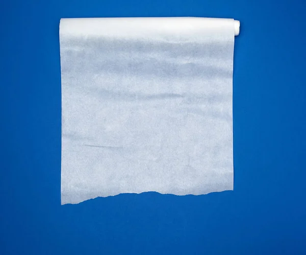 Odvinutý bílý pergamen pečení papír na modrém pozadí — Stock fotografie