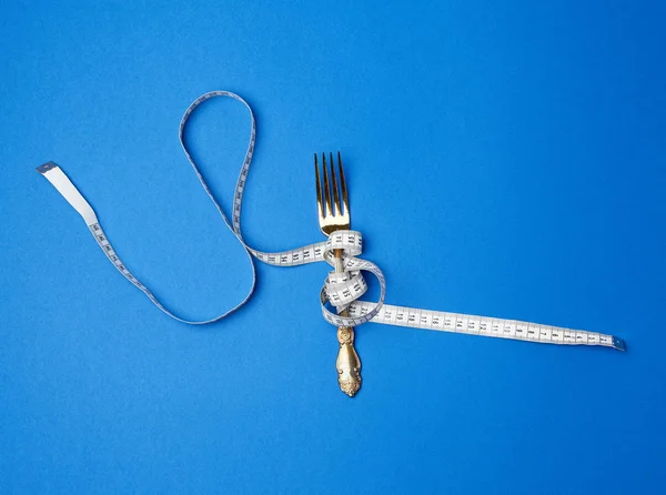 Iron fork wrapped in a measuring tape — Stock Photo, Image