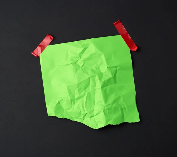 Green crumpled sheet of paper glued with rubber red adhesive tap — Stock Photo, Image