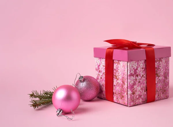 Pink gift box with bow, green spruce branch and two decorative p — ストック写真