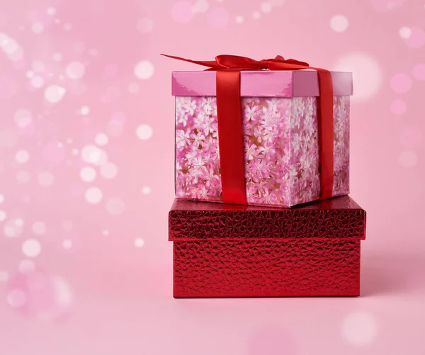 Hromada zabalených dárků na růžovém pozadí s bokeh — Stock fotografie