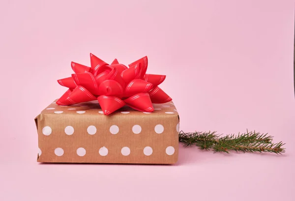 stack of kraft paper wrapped gifts, spruce branch