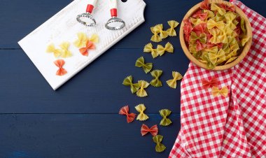 Tahta bir tabakta yay şeklinde çiğ makarna ve beyaz 