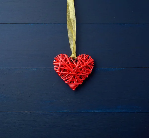 Corazón decorativo de mimbre rojo colgando de la cinta de seda dorada —  Fotos de Stock