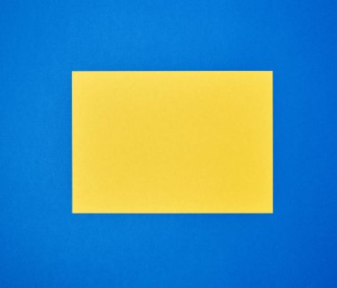 Mavi arkaplan üzerinde boş sarı A4 kağıdı