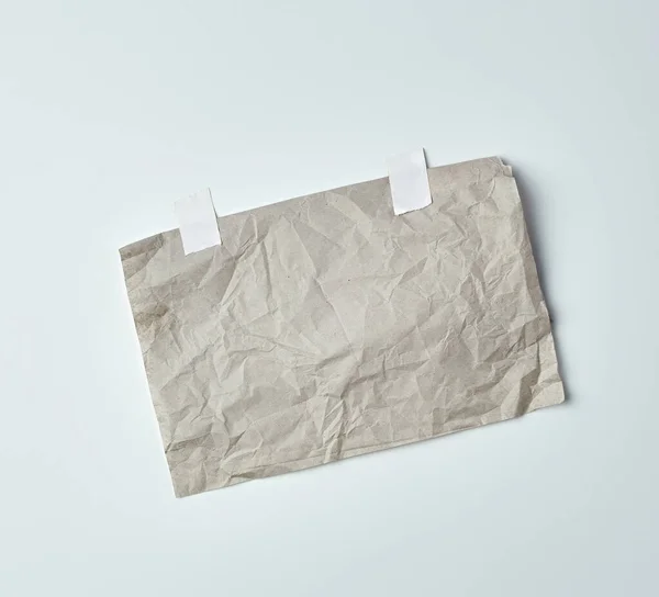 Γκρι τσαλακωμένο φύλλο χαρτιού κολλημένο με λευκή κολλητική ταινία — Φωτογραφία Αρχείου