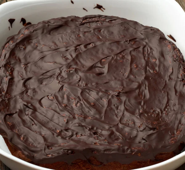 Bolo de chocolate brownie assado em uma placa de cerâmica branca . — Fotografia de Stock
