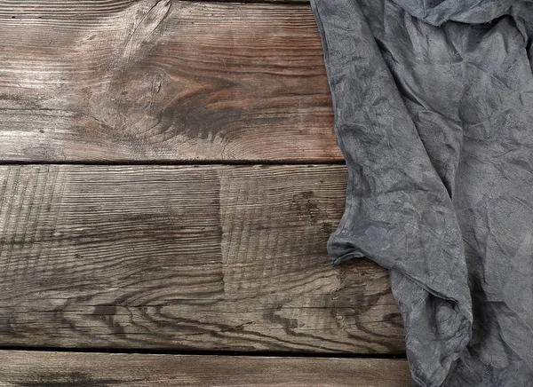 पुराने ग्रे से लकड़ी की पृष्ठभूमि पर काले वस्त्र रसोई तौलिया — स्टॉक फ़ोटो, इमेज