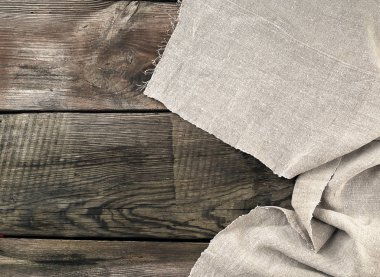 gri mutfak tekstil havlusu gri ahşap bir masaya katlanmış.