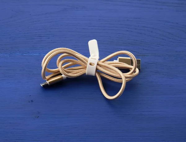 Изогнутый золотой кабель для зарядки электрооборудованием — стоковое фото