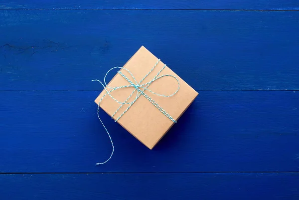 Bruin kartonnen geschenkdoosje op een blauwe houten achtergrond — Stockfoto