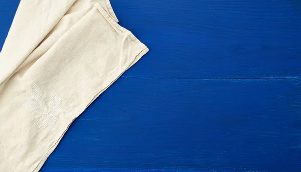 Toalla textil de cocina blanca doblada en una mesa de madera azul de o — Foto de Stock