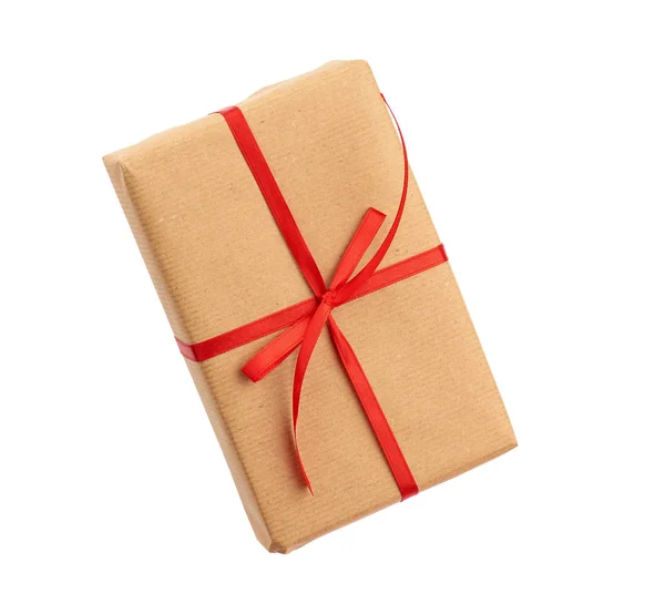 Caixa retangular envolto em papel marrom e amarrado com um arco vermelho , — Fotografia de Stock