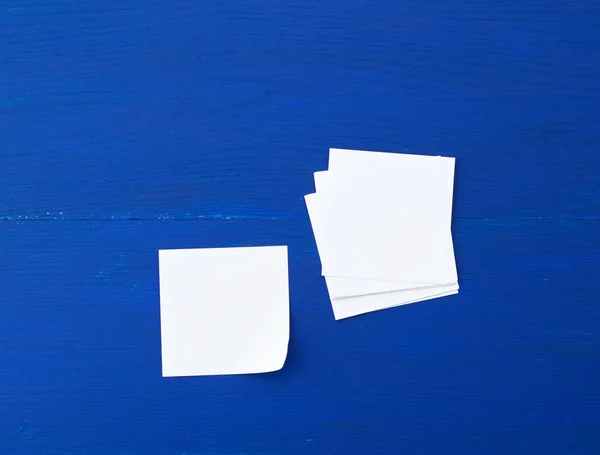 Prázdný bílý list papíru na modrém dřevěném pozadí — Stock fotografie