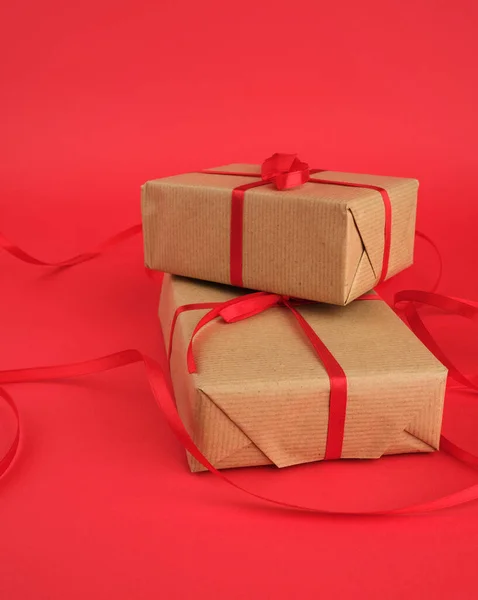 Square box wrapped in brown kraft paper and tied with a red thin — 스톡 사진