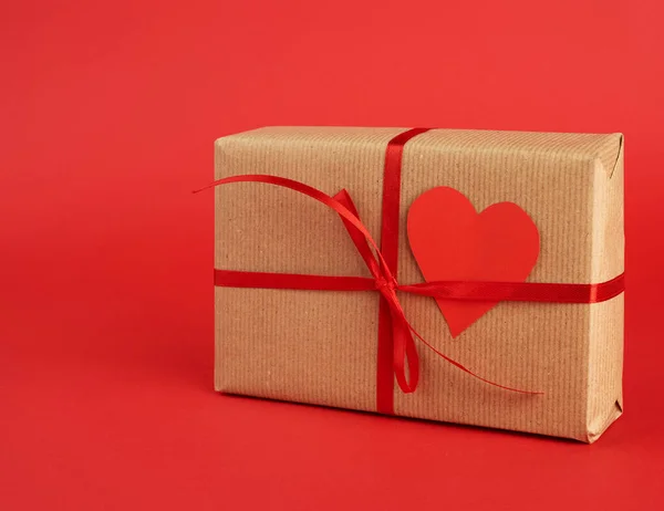 Wrapped square box with a gift in brown craft paper and tied wit — 스톡 사진