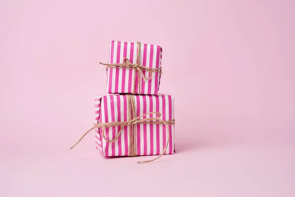 Two boxes wrapped in pink paper and tied with a brown rope on a — ストック写真