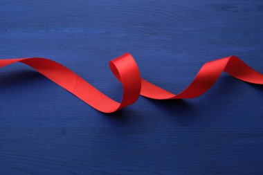 kırmızı ipek ince kurdele mavi ahşap arka planda bükülmüş