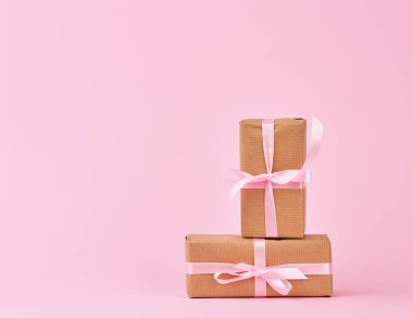 Kahverengi kraft kağıdına sarılı ve ipek R ile bağlanmış kutularda hediyeler.