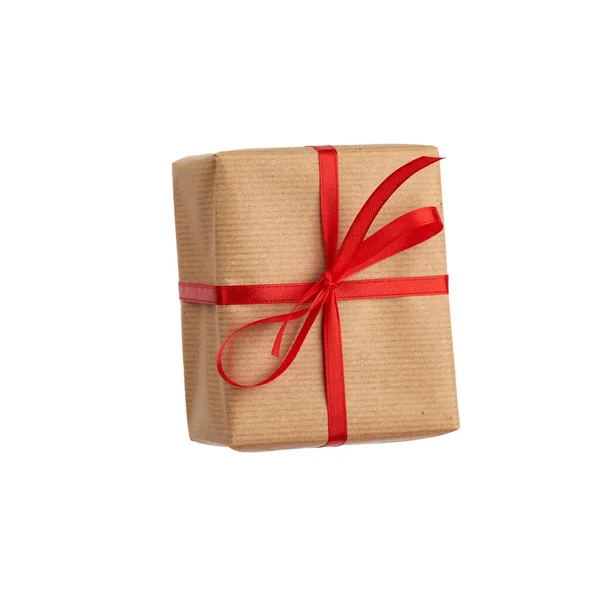 Caixa retangular envolto em papel marrom e amarrado com um arco vermelho , — Fotografia de Stock