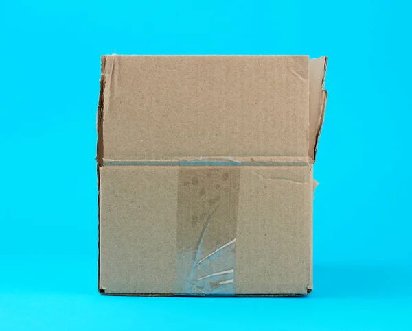 Caja de cartón marrón abierto sobre un fondo azul —  Fotos de Stock