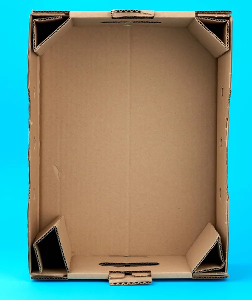 Caja de cartón vacía rectangular de papel marrón sobre un fondo azul — Foto de Stock