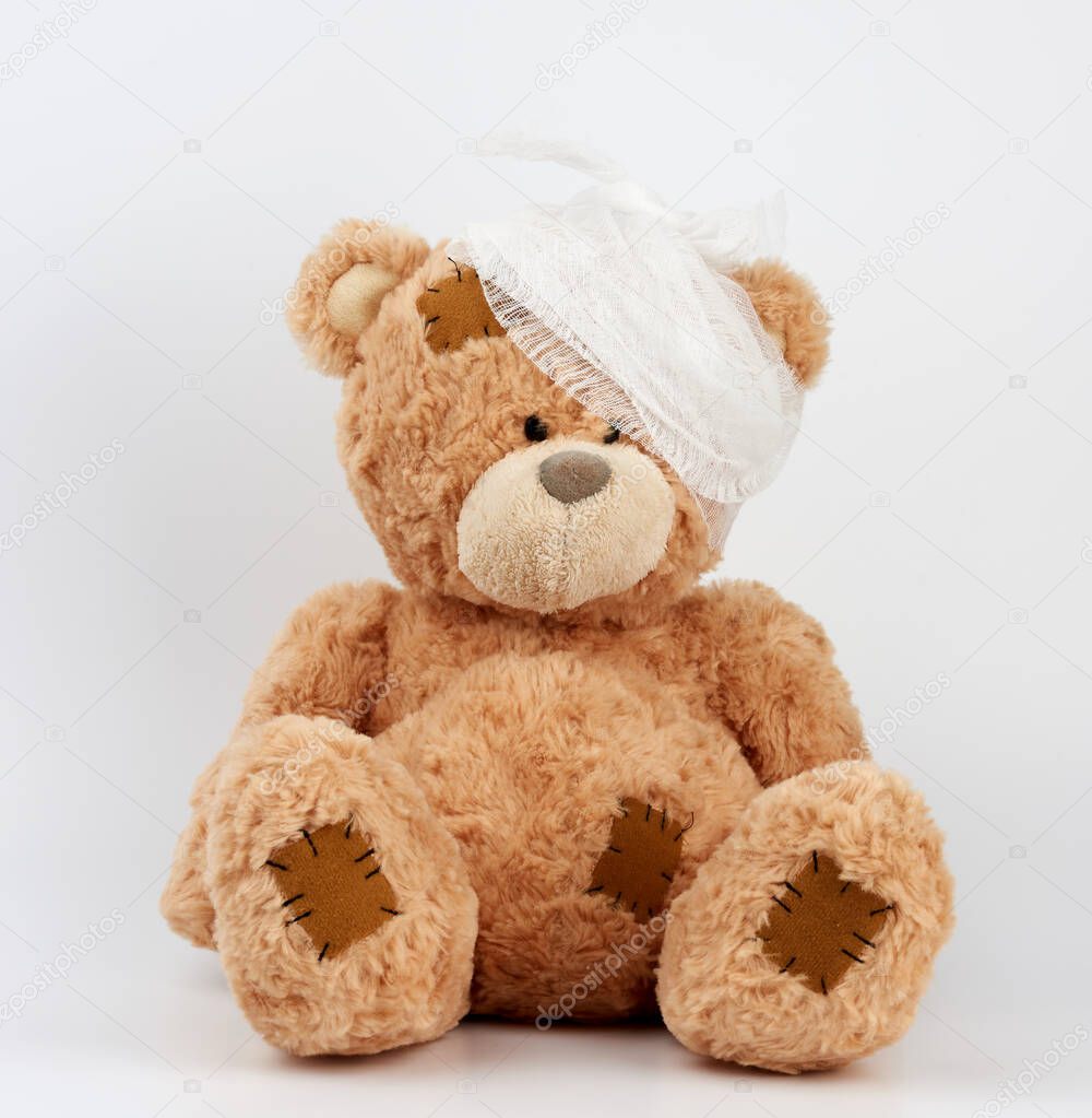 big teddy bear with a bandaged head in a white medical bandage o