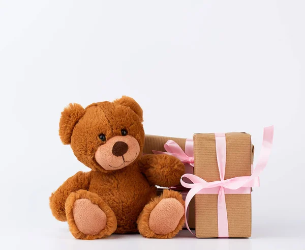 Бурый плюшевый мишка, стопка подарков в коробках, завернутых в коричневую бумагу — стоковое фото
