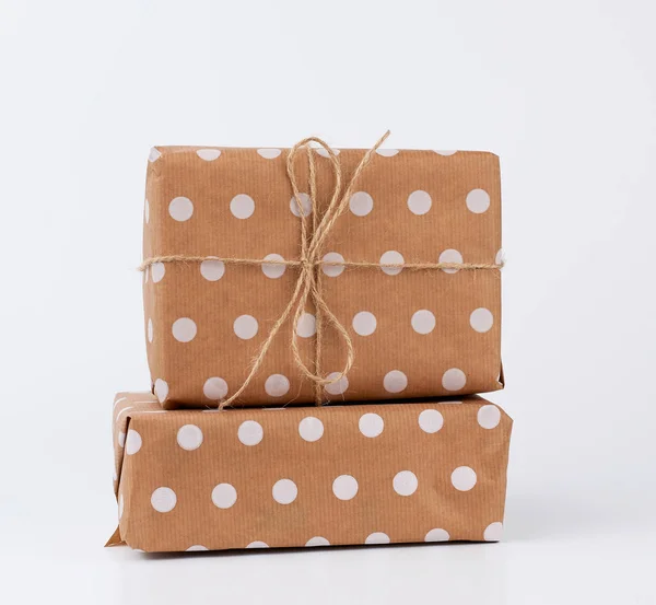 Hromada dárků v krabicích zabalených v hnědém kraft papíru a svázaných wi — Stock fotografie