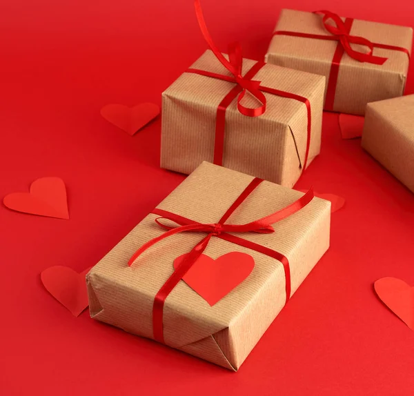 Box wrapped in brown kraft paper and tied with a red thin silk r — 스톡 사진