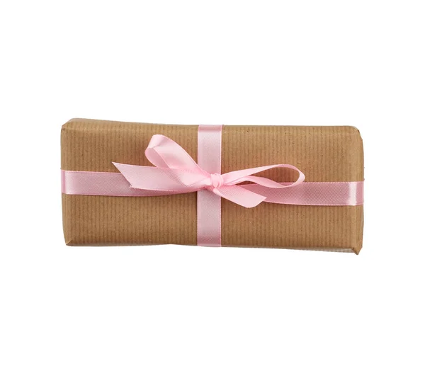 Box wrapped in brown kraft paper and tied with a pink ribbon — ストック写真