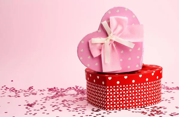 Caixa de presente rosa e vermelho fechado na forma de um coração com um arco — Fotografia de Stock