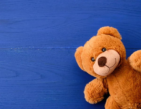 brown teddy bear on a blue wooden background