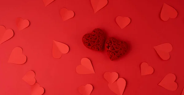 Καρδιές κομμένες από κόκκινο χαρτί σε κόκκινο φόντο, εορταστικό backdro — Φωτογραφία Αρχείου