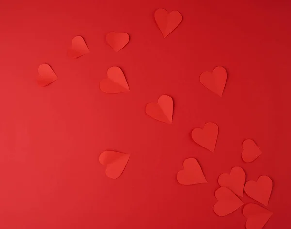 Hearts cut out of red paper on a red background, festive backdro — Stock Photo, Image