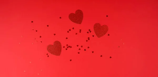 Paper red shiny decorative hearts on a red background — Stock Photo, Image