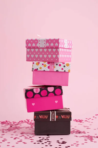 Hromada lepenkových čtvercových dárkových krabic na růžovém pozadí — Stock fotografie