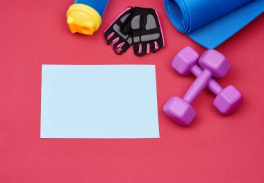 Boş beyaz kağıt ve bir çift mor plastik halter.