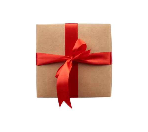 Vierkante doos verpakt in bruin kraftpapier en vastgebonden met een rood lint — Stockfoto