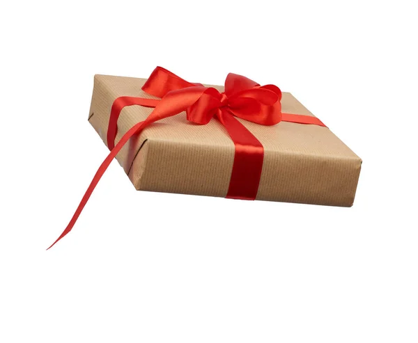 Vierkante doos verpakt in bruin kraftpapier en gebonden met een zijden rood — Stockfoto