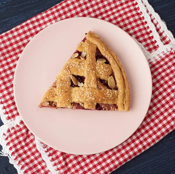 Tranche triangulaire de tarte aux cerises cuite sur une assiette ronde rose — Photo