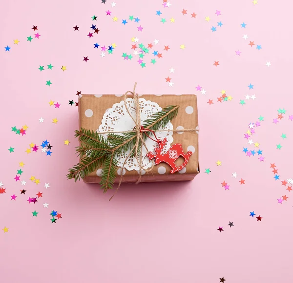 Kahverengi kraft kağıdına sarılı dikdörtgen bir kutu ve bir halatla bağlanmış.