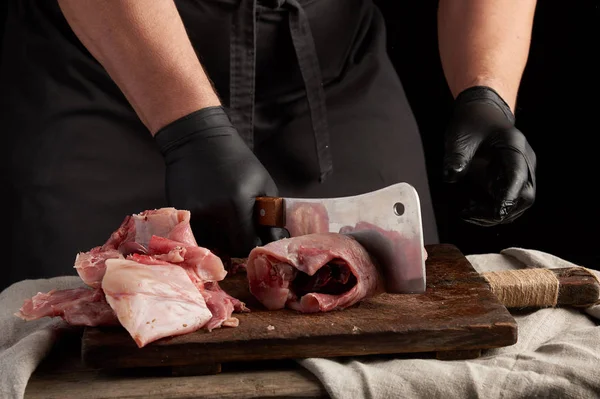 Chef in black latex gloves holds a big knife and cuts into piece — Stock Photo, Image