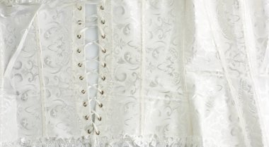 Bağcıklı beyaz saten bir korse parçası.