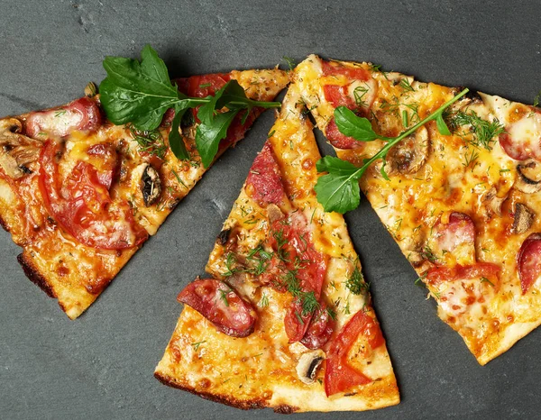 baked round pizza with smoked sausages, mushrooms, tomatoes, che