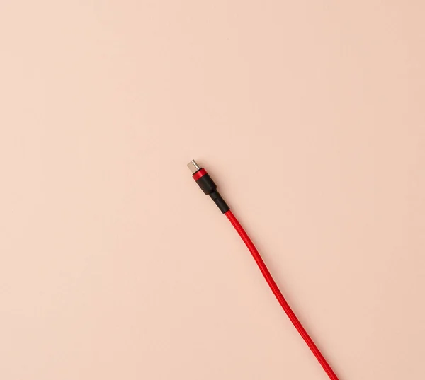 Mikrokabel do ładowania urządzeń mobilnych w czerwonym oplocie tekstylnym — Zdjęcie stockowe